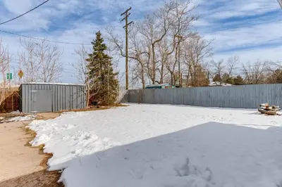 a driveway covered in snow next to a fence at Covered Patio, Gas Grill and Yard Sheridan Home! in Sheridan