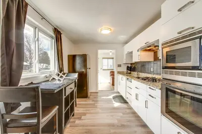 a kitchen with white cabinets and a black counter top at Covered Patio, Gas Grill and Yard Sheridan Home! in Sheridan