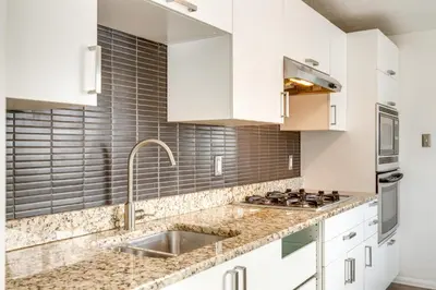 a kitchen with white cabinets and a sink at Covered Patio, Gas Grill and Yard Sheridan Home! in Sheridan