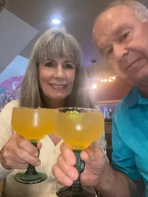 a man and woman holding up two glasses of beer at Colorado Bed & Breakfast with beautiful views in Evergreen