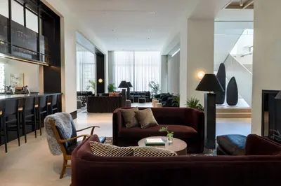 a living room with couches and a table at Kimpton Claret Hotel by IHG in Denver