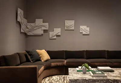 a living room with a brown couch and some pictures on the wall at Kimpton Claret Hotel by IHG in Denver