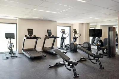 a gym with several treadmills and exercise bikes at Kimpton Claret Hotel by IHG in Denver