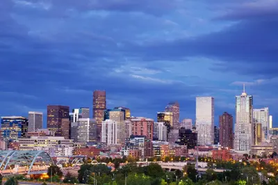 a view of a city skyline at night at Kimpton Claret Hotel by IHG in Denver