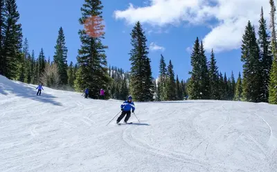 a group of people skiing down a snow covered slope at Gateway Lodge 5027 by SummitCove Lodging in Keystone