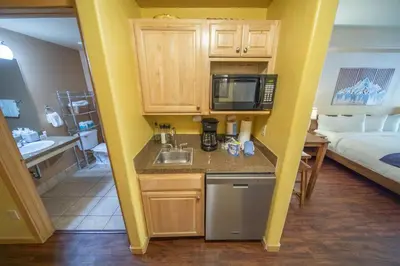 a small kitchen with a sink and a room with a bed at Gateway Lodge 5027 by SummitCove Lodging in Keystone