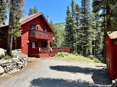 a red house with a red fence in front of it at Shady Pines- Cozy Mountain Retreat in Idaho Springs