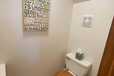 a bathroom with a toilet with a sign on the wall at Shady Pines- Cozy Mountain Retreat in Idaho Springs