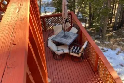 a patio with a table and chairs on a deck at Shady Pines- Cozy Mountain Retreat in Idaho Springs