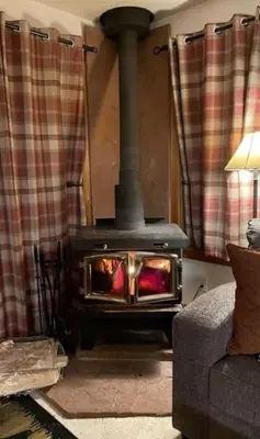 a fireplace in a living room with a couch at Shady Pines- Cozy Mountain Retreat in Idaho Springs