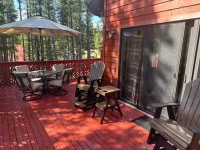 a deck with a table and chairs and an umbrella at Shady Pines- Cozy Mountain Retreat in Idaho Springs