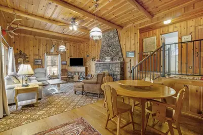 a living room with a table and a fireplace at Hidden Pines -- EV#3034 home in Estes Park