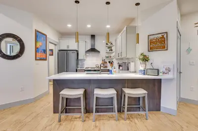 a kitchen with a large counter with two stools at Downtown Winter Park Condo about 3 Mi to Skiing! in Winter Park