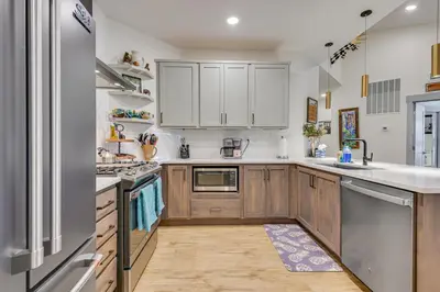 a kitchen with wooden cabinets and white appliances at Downtown Winter Park Condo about 3 Mi to Skiing! in Winter Park