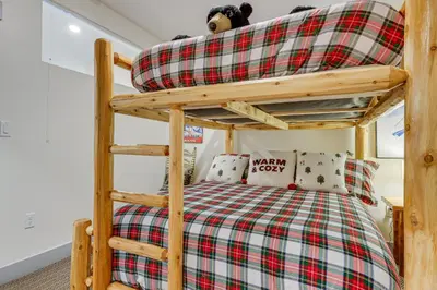 a bedroom with a bunk bed with a red and green plaid at Downtown Winter Park Condo about 3 Mi to Skiing! in Winter Park