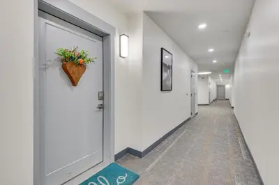 a hallway with a door with a flower pot on it at Downtown Winter Park Condo about 3 Mi to Skiing! in Winter Park