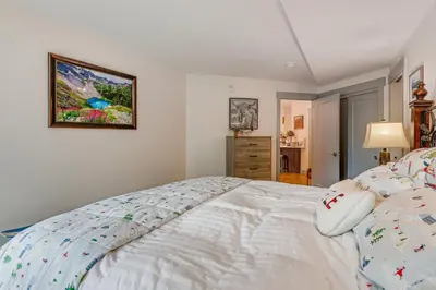 a bedroom with a bed and a picture on the wall at Downtown Winter Park Condo about 3 Mi to Skiing! in Winter Park