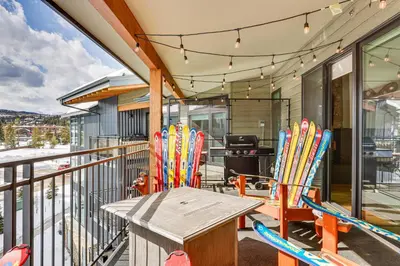 a deck with chairs and a table and some lights at Downtown Winter Park Condo about 3 Mi to Skiing! in Winter Park