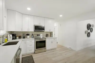 a kitchen with white cabinets and stainless steel appliances at 5-Bedrooms! Stylish and Modern Home, Pets Welcome! in Arvada