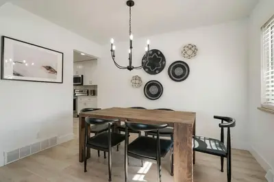 a dining room table with black chairs and a chandelier at 5-Bedrooms! Stylish and Modern Home, Pets Welcome! in Arvada
