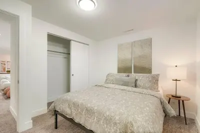 a white bedroom with a bed and a lamp at 5-Bedrooms! Stylish and Modern Home, Pets Welcome! in Arvada