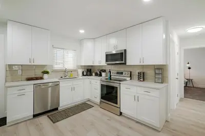 a white kitchen with white cabinets and appliances at 5-Bedrooms! Stylish and Modern Home, Pets Welcome! in Arvada
