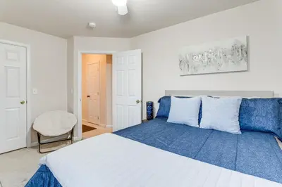 a bedroom with a large bed with blue pillows at 12 Mi to DIA Cozy Denver Townhome with Fireplace! in Aurora