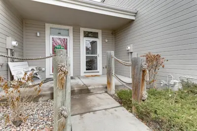 a house with a wooden fence in front of it at 12 Mi to DIA Cozy Denver Townhome with Fireplace! in Aurora
