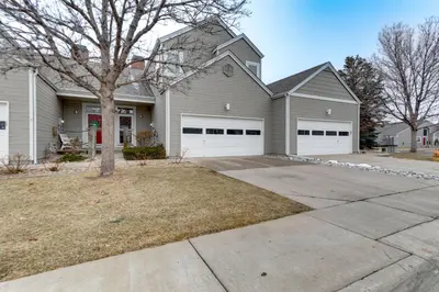 a house with two garage doors and a tree at 12 Mi to DIA Cozy Denver Townhome with Fireplace! in Aurora