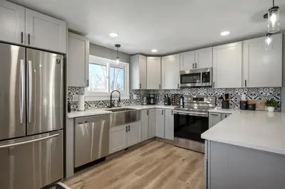 a kitchen with white cabinets and stainless steel appliances at Serene 4-Bedroom Getaway in Arvada! Pet-friendly! in Arvada