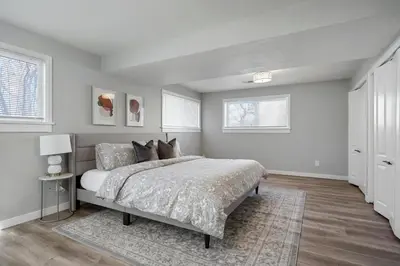 a white bedroom with a bed and two windows at Serene 4-Bedroom Getaway in Arvada! Pet-friendly! in Arvada