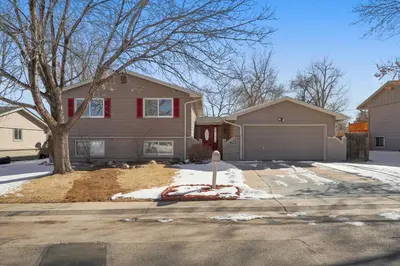 a house with a tree and a garage at Serene 4-Bedroom Getaway in Arvada! Pet-friendly! in Arvada