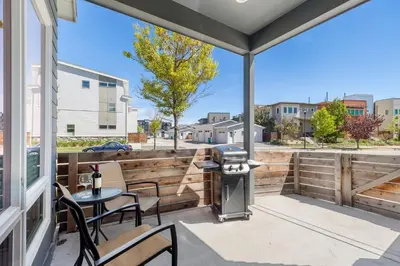 a patio with a grill and a table and chairs at Elegant Oasis - Fireplaces, King Beds, Mtn Views! in Fort Collins