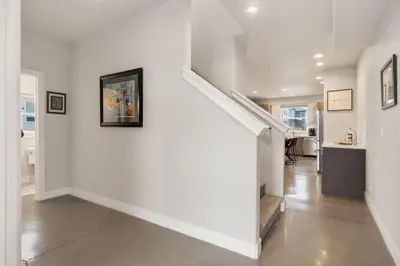 a white hallway with a staircase in a house at Elegant Oasis - Fireplaces, King Beds, Mtn Views! in Fort Collins