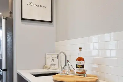 a kitchen counter with a bottle of wine and glasses at Elegant Oasis - Fireplaces, King Beds, Mtn Views! in Fort Collins
