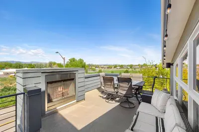 a patio with a fireplace and a table and chairs at Elegant Oasis - Fireplaces, King Beds, Mtn Views! in Fort Collins