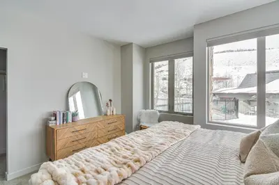a bedroom with a bed with a dresser and a mirror at Granby Retreat with Community Pool Ski-InandSki-Out! in Granby