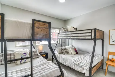 a bedroom with two bunk beds and a desk at Granby Retreat with Community Pool Ski-InandSki-Out! in Granby