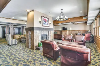 a lobby with leather furniture and a fireplace at Granby Retreat with Community Pool Ski-InandSki-Out! in Granby