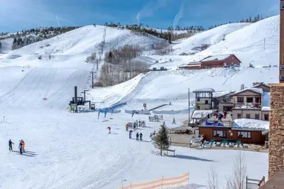 a group of people skiing down a snow covered slope at Granby Retreat with Community Pool Ski-InandSki-Out! in Granby