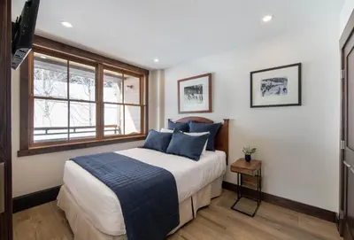 a bedroom with a bed with blue pillows and a window at Premium Unit 1301 - 1 Bedroom - Zephyr Mtn Lodge condo in Winter Park
