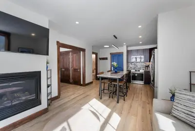 a living room with a fireplace and a table and chairs at Premium Unit 1301 - 1 Bedroom - Zephyr Mtn Lodge condo in Winter Park