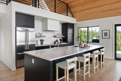 a kitchen with a large island with bar stools at Sky House chalet in Tabernash