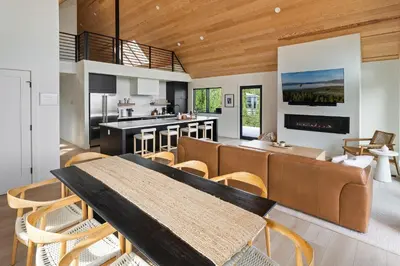 a kitchen and living room with a table and chairs at Sky House chalet in Tabernash