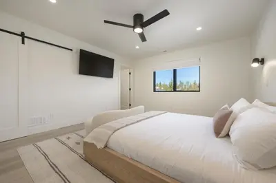 a white bedroom with a bed and a ceiling fan at Sky House chalet in Tabernash