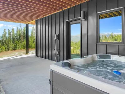 a large bathroom with a hot tub with a view at Sky House chalet in Tabernash