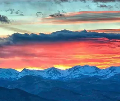 a painting of a sunset over the mountains at Mountain Top Luxury Red Rocks Hot tub Sauna Views in Golden