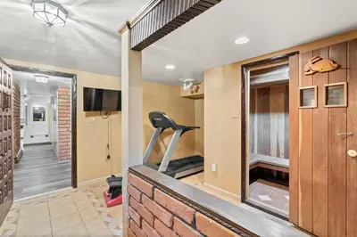a room with a gym with a treadmill and a hallway at Mountain Top Luxury Red Rocks Hot tub Sauna Views in Golden