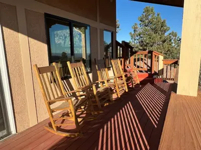 a row of rocking chairs sitting on a porch at Mountain Top Luxury Red Rocks Hot tub Sauna Views in Golden