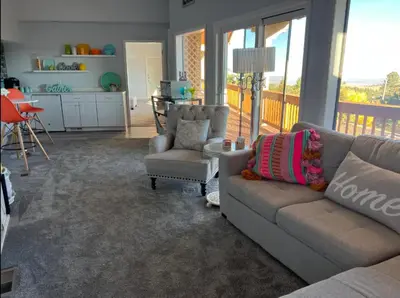 a living room with a couch and chairs and a balcony at Mountain Top Luxury Red Rocks Hot tub Sauna Views in Golden